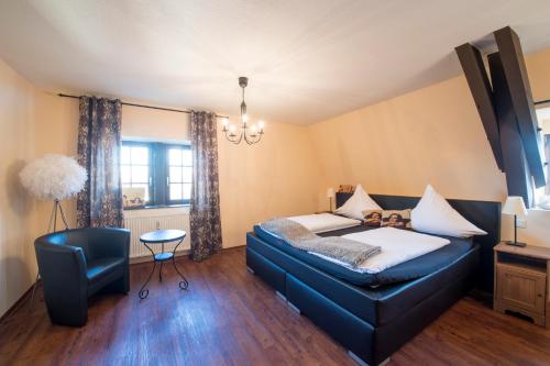 a bedroom with a blue couch and a chair at Leipziger Hof in Fulda