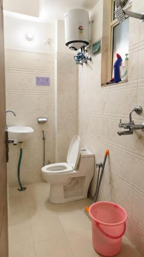 a bathroom with a toilet and a sink at Cozy Den in Jaipur