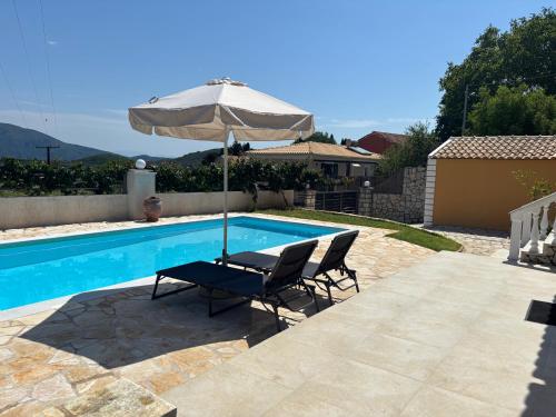 a pair of chairs and an umbrella next to a swimming pool at Lazaros in Ágios Matthaíos