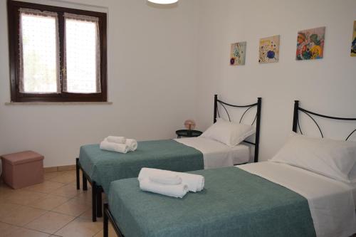 a room with two beds with green and white sheets at Il rifugio magico in Valmontone
