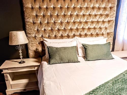 a bedroom with a bed with a large headboard at Rosahoff Guesthouse in Windhoek