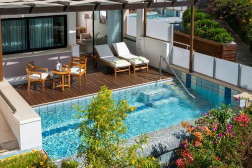 a swimming pool with chairs and a table on a building at Constantinou Bros Asimina Suites Hotel in Paphos