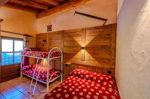 a bedroom with two bunk beds in a room with wooden walls at Residence Trompe-L'oeil in Champoluc