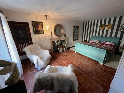a living room with a bed and two white chairs at La Clé D'Alice in Montmorillon