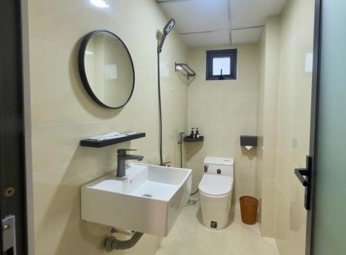 a bathroom with a sink and a toilet and a mirror at Ann Arbor Hotel in Ho Chi Minh City