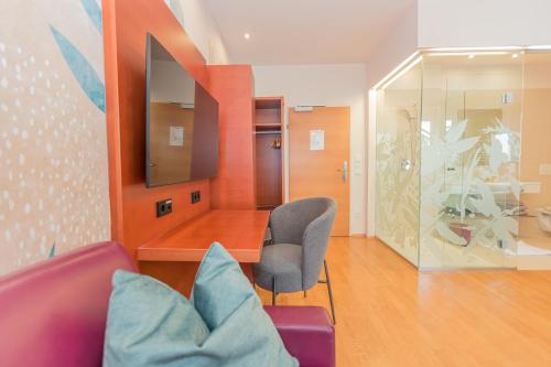 a living room with a couch and a chair at Hotel Stadt Wien in Bad Schallerbach
