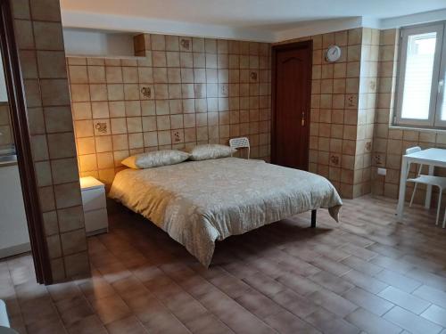 a bedroom with a bed and a tiled wall at B&B Campisi Anna in Altamura