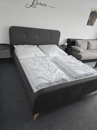 a bed with white sheets and pillows in a bedroom at Soleil et me in Burgtiefe auf Fehmarn 