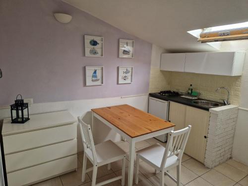 a kitchen with a wooden table and chairs at Calaluna in La Maddalena
