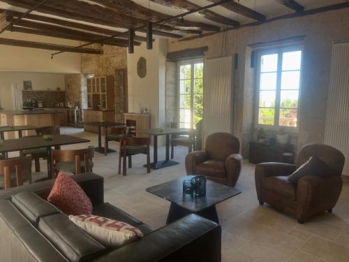 a living room with a couch and chairs and tables at B&B Manoir Calmeer in Thenon