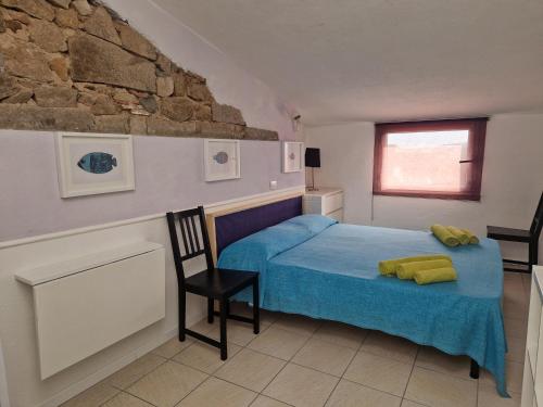 a bedroom with a blue bed and a stone wall at Calaluna in La Maddalena