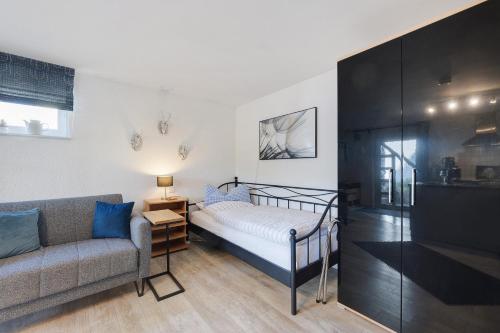 a bedroom with a bed and a couch at Ferienwohnungen Knodel in Sachsenheim