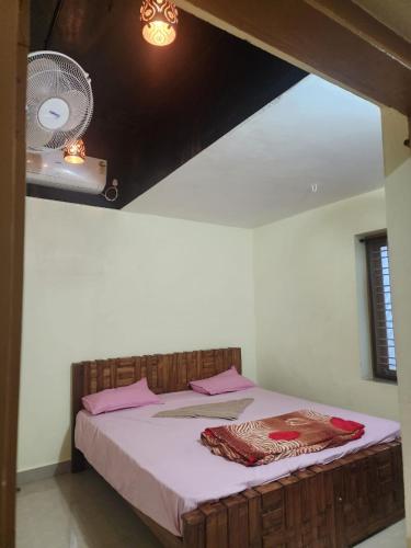 a bedroom with a bed with pink sheets and a fan at Mount View Attappadi in Agali