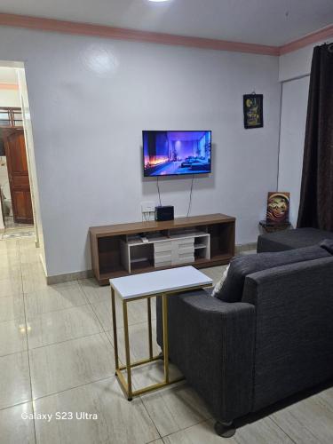a living room with a couch and a tv at Kim'sPlace in Mombasa
