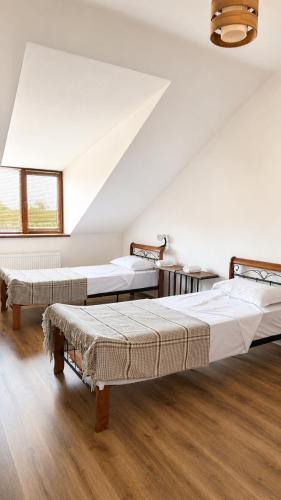 three beds in a room with wooden floors at Sweet Alvani in Akhmety