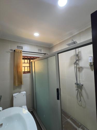 a bathroom with a shower and a sink and a toilet at JAYNIEL Apartments #2 in Lusaka