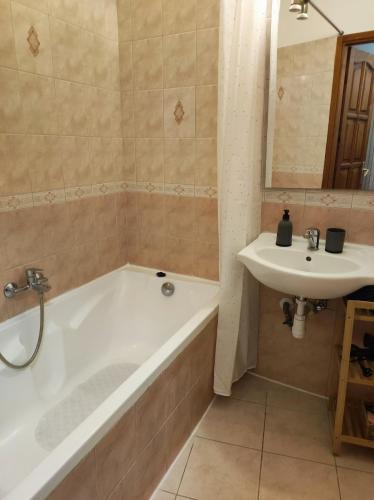a bathroom with a tub and a sink at Campana Apartment - Szigetvár in Szigetvár
