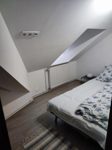 a bedroom with a bed and a sloped ceiling at Campana Apartment - Szigetvár in Szigetvár