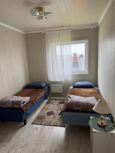 a bedroom with two beds and a window at Arctic View Apartament Vardø in Vardø