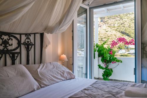 a bedroom with a bed and a window with a plant at Villa Areto in Kamares