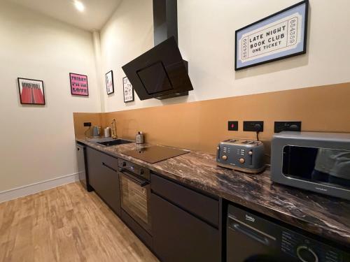 a kitchen with a sink and a microwave on a counter at The Holyrood Mega-Quarters in Edinburgh