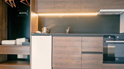 a kitchen with wooden cabinets and a stove at Eden Hotel in Rrogozhinë