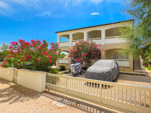 a house with a white fence and pink flowers at Apartman Adriatic View in Vir