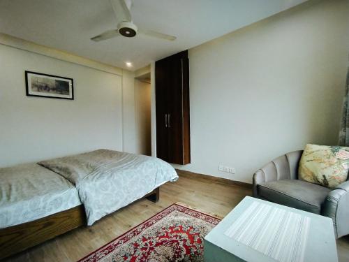 a bedroom with a bed and a couch and a table at Luxe Villa in Murree