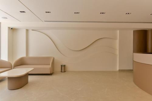 a living room with a couch and a table at Melange Hotel - Golf course road in Gurgaon