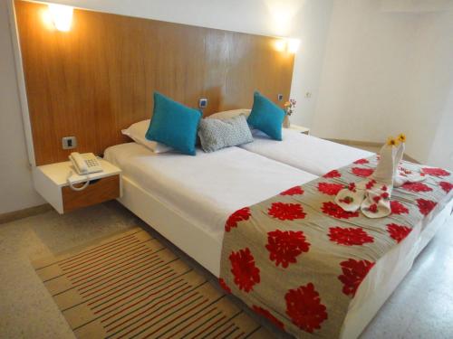 a bedroom with a large bed with blue and red sheets at Chiraz Club - Families Only in Monastir