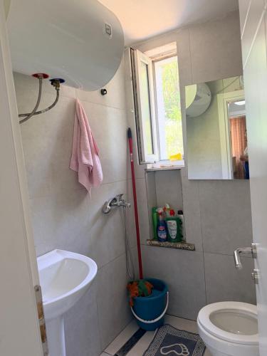 a bathroom with a sink and a toilet and a mirror at Bella Vista Apartment in Lezhë
