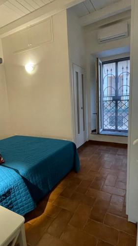 a bedroom with a blue bed and a window at Al numero 15 in Castel Gandolfo