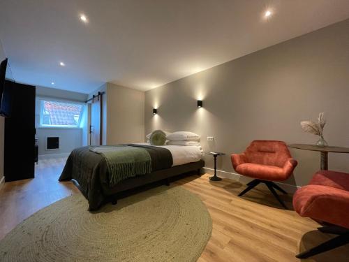 a bedroom with a bed and a chair and a window at Hotel-restaurant "Lely" in Oude-Tonge