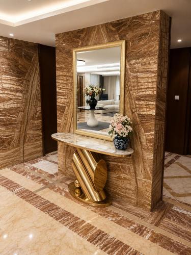 a room with a mirror and a table with flowers at IQ Hotel alhamra فندق اي كيو الحمراء in Jeddah