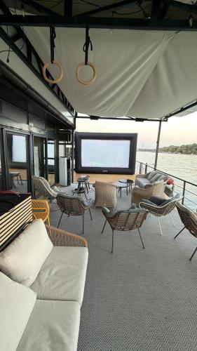 a boat with couches and chairs and a large screen at Swan in Belgrade