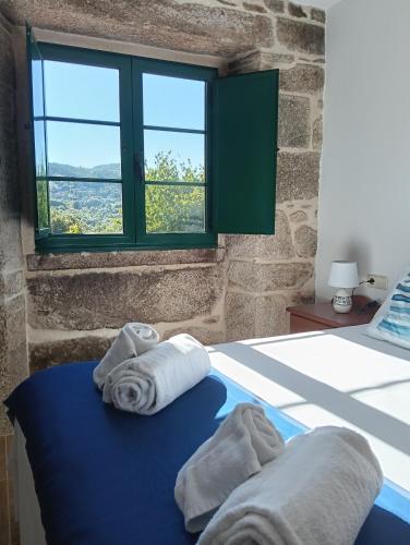 a bedroom with two towels on a bed with a window at alma de quireza in Santo Tomé