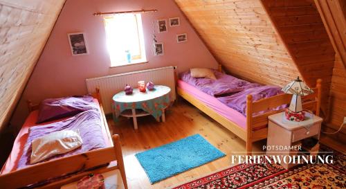 a attic bedroom with two beds and a table at Potsdamer Ferienwohnung in Potsdam