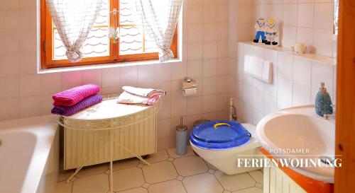 een badkamer met een wastafel, een bad en een toilet bij Potsdamer Ferienwohnung in Potsdam