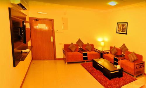 a living room with two chairs and a couch at Nelover Hafar-Serviced apartments in Hafr Al Baten