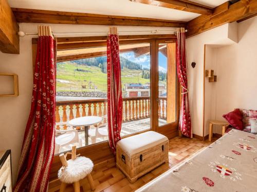 a room with a large window with a view of a mountain at Chaleureux appartement au pied des pistes avec parking et animaux admis - FR-1-505-65 in Notre-Dame-de-Bellecombe