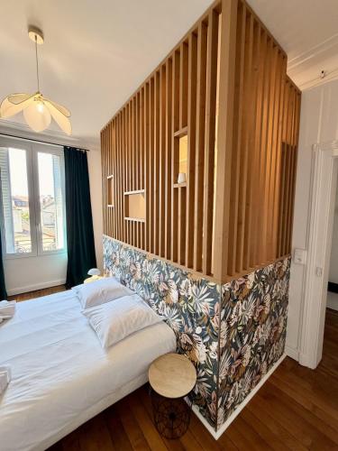a bedroom with a large bed with a wooden wall at Le Robespierre #Reims in Reims