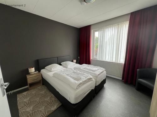 a bedroom with a large bed and a window at Hermes Appartementen in Berg en Terblijt