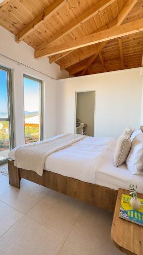 a bedroom with a large bed with a wooden ceiling at Villa Thea with Pool & panoramic Sea View in Kotrónion