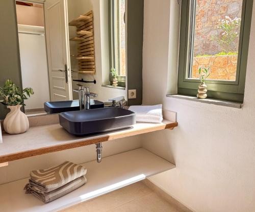 a bathroom with a sink and a mirror at Villa Thea with Pool & panoramic Sea View in Kotrónion