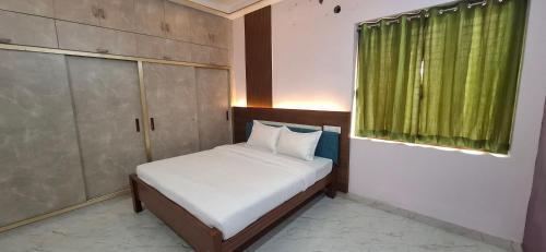 a small bed in a room with a green window at The Green stays in Madurai