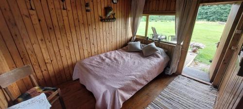 a bedroom with a bed in a room with a window at Little Red Sauna by the Sea in Leesi