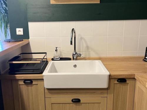 a kitchen with a white sink and a counter at Gîte spacieux en campagne avec jacuzzi, sauna et jeux extérieurs - FR-1-496-52 in Saint-Just-la-Pendue