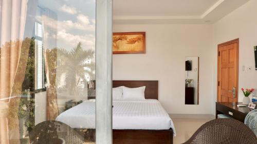 a bedroom with a bed and a large window at Hila Hotel Vạn Ninh in Vạn Ninh