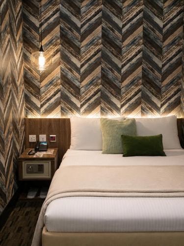 a hotel room with a bed and a brick wall at V-one Hotel - Ningxia No. 2 Inn in Taipei