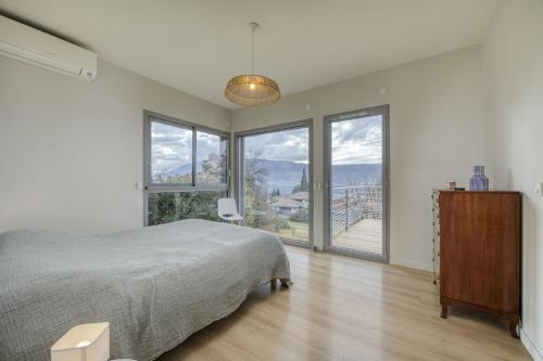 a bedroom with a large bed and large windows at Wooden Villa 4 in Veyrier-du-Lac